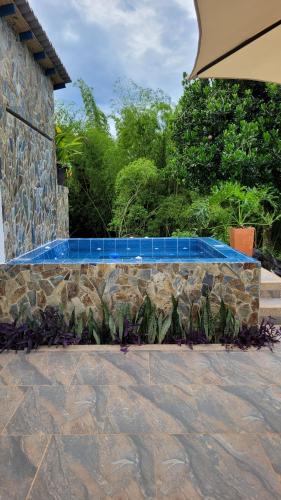 a stone retaining wall with blue tiles on it at Alojamiento Reserva Natural La Maria in Armenia