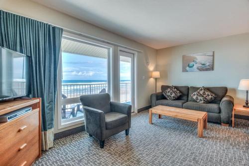 a living room with a couch and a tv and a window at Oceanfront Suite - 2 Queen Beds - Beach Access - Pool and Hot Tub in Lincoln City