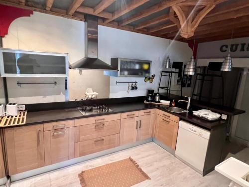 une cuisine avec des armoires en bois et un comptoir noir dans l'établissement VILLA PARADIS piscine privee sans vis à vis et plage, à Vendres