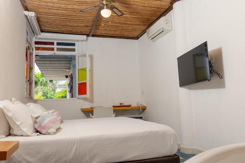 a bedroom with a bed and a tv on the wall at Placita Vieja Hotel Boutique Spa in Santa Marta