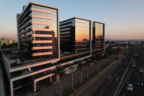 three tall buildings on a city street with traffic at Loft confortável com garden in Canoas