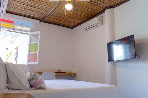a bedroom with a bed and a tv on the wall at Placita Vieja Hotel Boutique Spa in Santa Marta