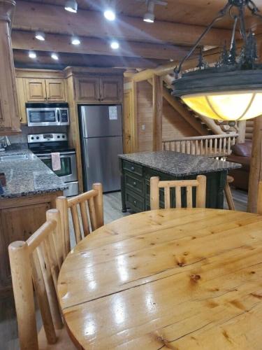 a wooden table and chairs in a kitchen with a wooden table at Summer Adventure Awaits! Hidden Pines- Yellowstone in Island Park