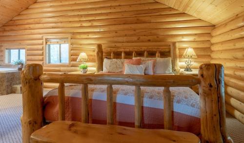 a bedroom with a bed in a log cabin at Summer Adventure Awaits! Hidden Pines- Yellowstone in Island Park