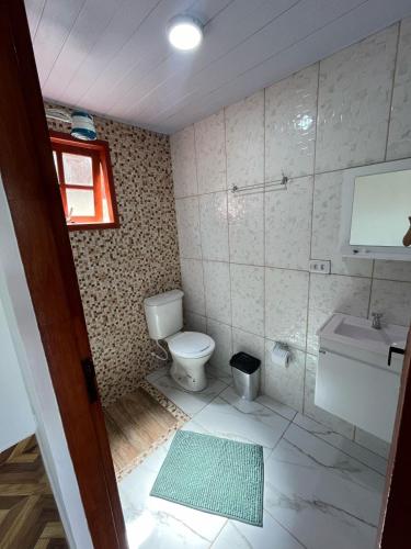 a bathroom with a toilet and a sink at Chalés Paraíso Guararema 4 in Guararema