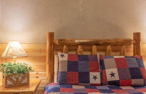 a bed with a wooden headboard and a table with a lamp at Summer Adventure Awaits! Hidden Pines- Yellowstone in Island Park