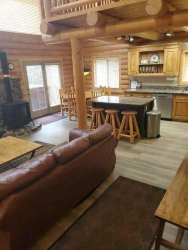 a living room with a couch in a log cabin at Summer Adventure Awaits! Hidden Pines- Yellowstone in Island Park