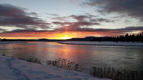 a sunset over a river with snow on the ground at Summer Adventure Awaits! Hidden Pines- Yellowstone in Island Park