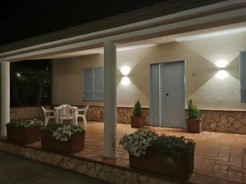 Un patio con mesa, sillas y luces. en Villa Paradise, en Capo Vaticano