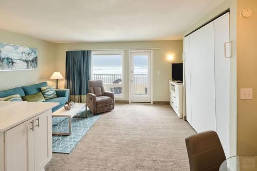 a living room with a blue couch and a chair at Stunning Oceanfront Suite - Full Kitchen - Pool and Hot Tub in Lincoln City