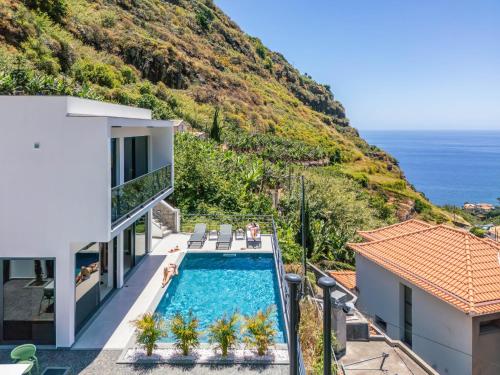 an image of a house with a swimming pool and the ocean at Atlantic Pebble Villa in Ribeira Brava