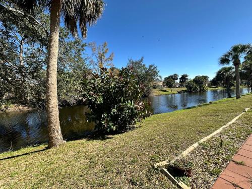 vistas a un río con palmeras y una acera en Furnished canal private home, en Port Charlotte