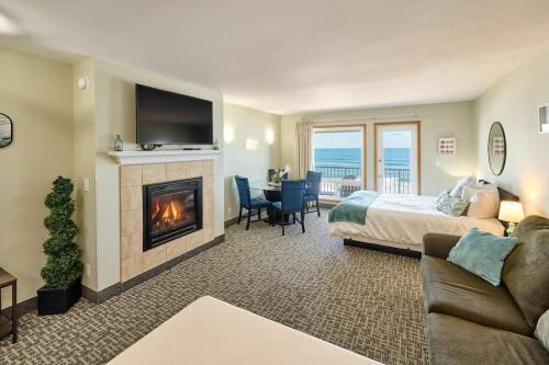 a hotel room with a bed and a fireplace at Deluxe Ocean View Family Suite - Sleeps Six - Heated Pool & Hot Tub in Lincoln City