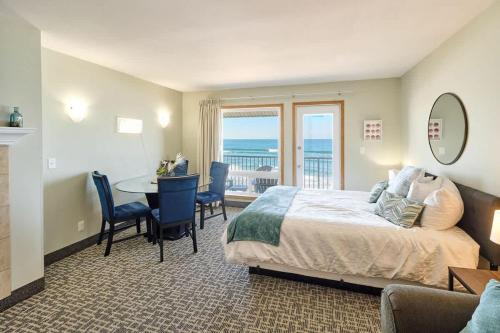 a bedroom with a bed and a table with chairs at Deluxe Ocean View Family Suite - Sleeps Six - Heated Pool & Hot Tub in Lincoln City