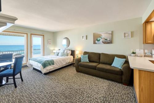 a bedroom with a bed and a couch and a table at Deluxe Ocean View Family Suite - Sleeps Six - Heated Pool & Hot Tub in Lincoln City