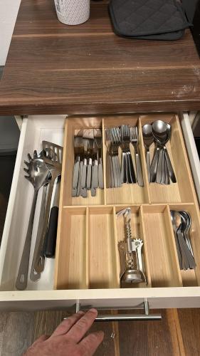 a drawer filled with lots of utensils on a counter at 80 m2 Rooftop Apartment with Balcony & Free Parking in Gerasdorf bei Wien