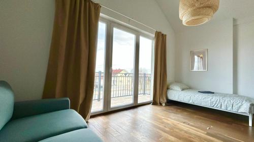 a living room with a couch and a large window at 80 m2 Rooftop Apartment with Balcony & Free Parking in Gerasdorf bei Wien