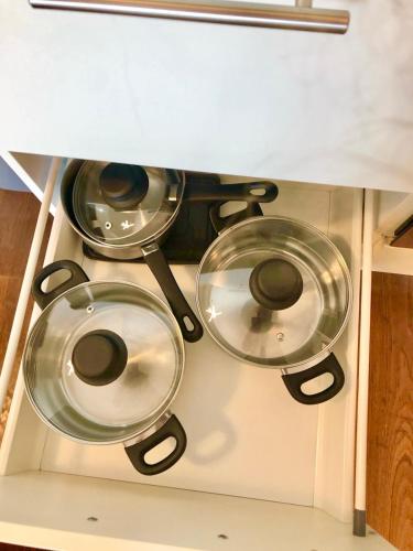 three pots and pans sitting on top of a stove at 80 m2 Rooftop Apartment with Balcony & Free Parking in Gerasdorf bei Wien