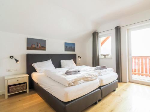 a bedroom with a large bed with white sheets at Sonnenalm in Mauterndorf