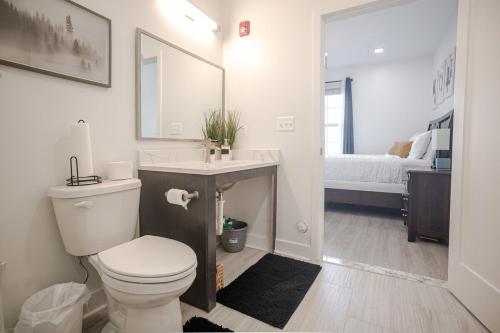 a bathroom with a toilet and a sink and a bed at FellPoint Harbor Hideaway Haven in Baltimore