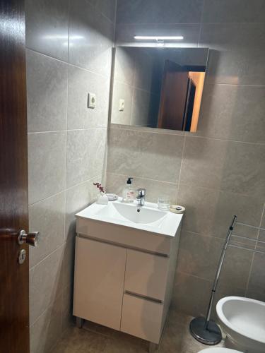 a bathroom with a sink and a toilet and a mirror at Bem Estar in Chaves