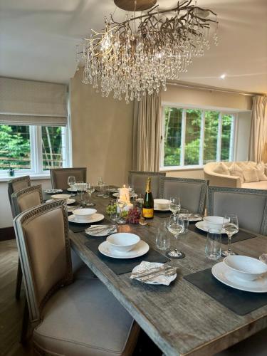 a dining room with a long table with chairs and a chandelier at North Cottage - A Stylish Family Retreat Once Owned by Beatrix Potter in Bowness-on-Windermere