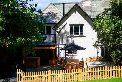a white house with a fence in front of it at North Cottage - A Stylish Family Retreat Once Owned by Beatrix Potter in Bowness-on-Windermere