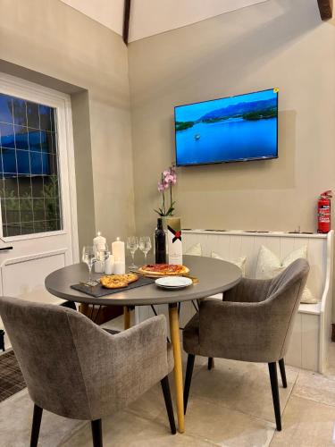 a dining room with a table and chairs and a tv at North Cottage - A Stylish Family Retreat Once Owned by Beatrix Potter in Bowness-on-Windermere