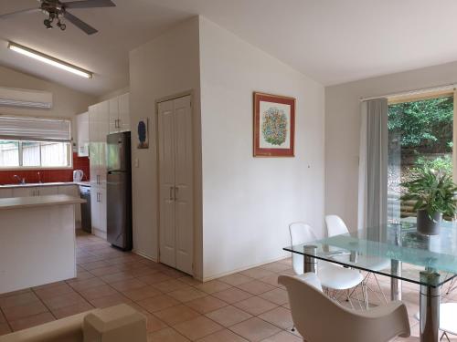 a kitchen and dining room with a glass table and chairs at Terrigal beach heaven secne in Terrigal