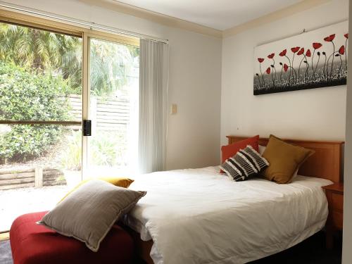 a bedroom with a large bed with a window at Terrigal beach heaven secne in Terrigal
