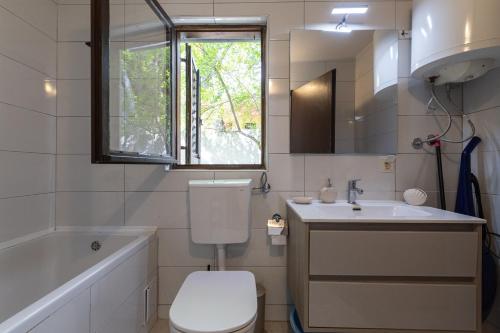 Un baño con inodoro, lavabo y ventana. en Seaside house for families with children Ivan Dolac, Hvar - 140, en Ivan Dolac