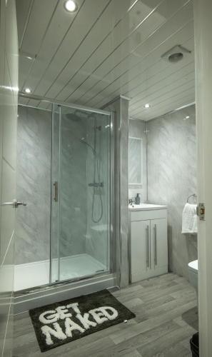 a bathroom with a glass shower with a sink and a toilet at Double story Suite in Rochdale in Rochdale