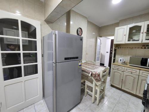 a kitchen with a refrigerator and a table in it at Unique Apartment in Sheraton Heliopolis in Cairo