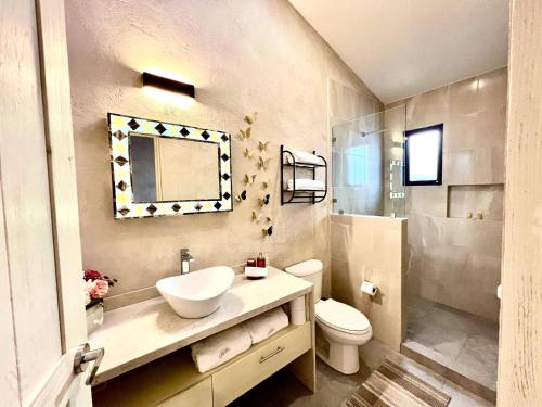 un bagno con lavandino, WC e specchio di Aida en ValQuirico a Santeagueda