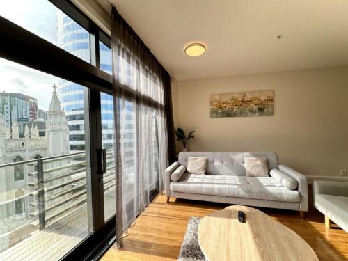 a living room with a couch and a large window at Boulcott Suites in Wellington