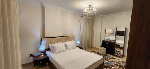 a bedroom with a bed and a chandelier at Unique Apartment in Sheraton Heliopolis in Cairo