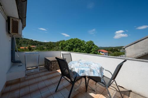 a patio with a table and chairs on a balcony at Apartments with parking space Zdrelac, Pasman - 8514 in Ždrelac