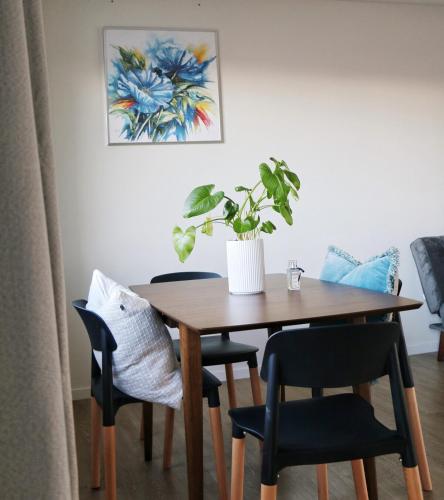 a dining room table with chairs and a potted plant at BLANC Suites Unit9 in Silverdale