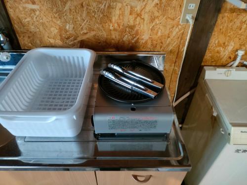 a toaster oven with a plate and utensils in it at INN Sodeshi 丹後 一棟貸し 海の宿 INN袖志 in Kyotango