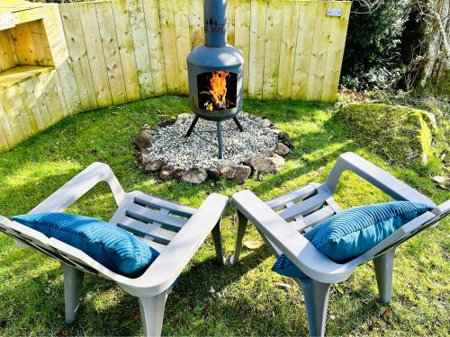 two chairs and a fire pit in a backyard at Brora Escapes in Brora