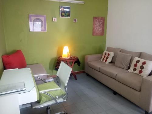 a living room with a couch and a table at RAIZ DEL CIELO, entre 2 jardines de ensueño in Cordoba