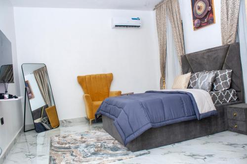 a bedroom with a bed and a chair and a mirror at Lexanni Havens in Lagos
