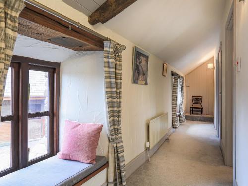 a hallway with a pink pillow sitting on a window sill at Rowes Farm in Marytavy