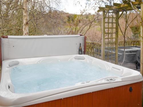 a bath tub sitting on top of a patio at Middle Wicket in Trusham