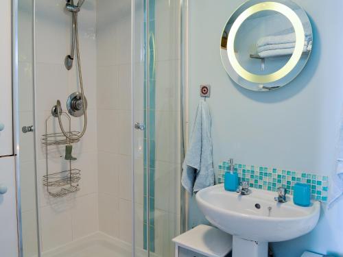 a bathroom with a shower and a sink and a mirror at Sea Yonder in Buckie