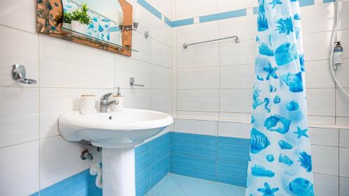 a bathroom with a sink and a shower curtain at Simon Ionian Balcony 1 - Kitchen, Sea View in Himare