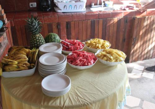 a table with bowls of fruit and plates on it at Hotel Santa Maria Inn in Alajuela City
