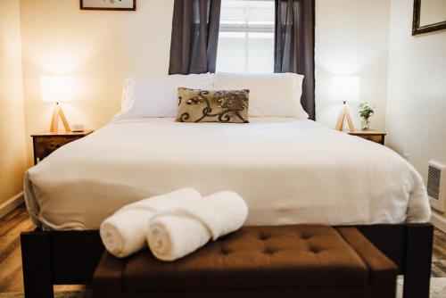 a bedroom with a bed with two towels on a stool at The Berkeley House in Klamath Falls