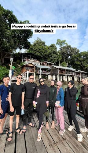 a group of people standing on a wooden dock at Olala Bungalows and Restaurant in Sabong