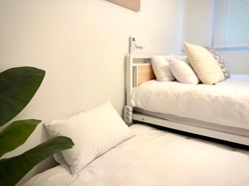 a bedroom with a bed with white sheets and pillows at HausKomma 서울 홍대,이태원,명동 짐보관 무료 주차 엘레베이터 새아파트 in Seoul